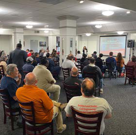 people sitting in chairs watching a presentation