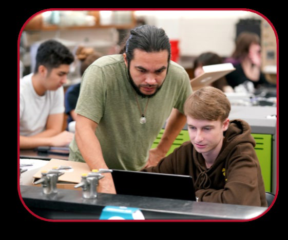 Man helping boy on computer