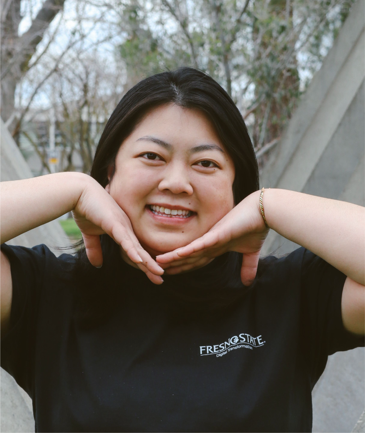 headshot of Jamie with both her hands on her chest