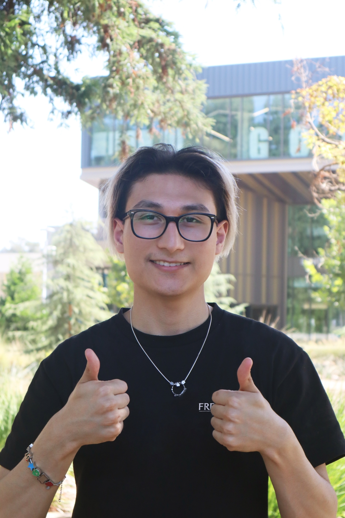 headshot of Nathan smiling and holding two thumbs up!