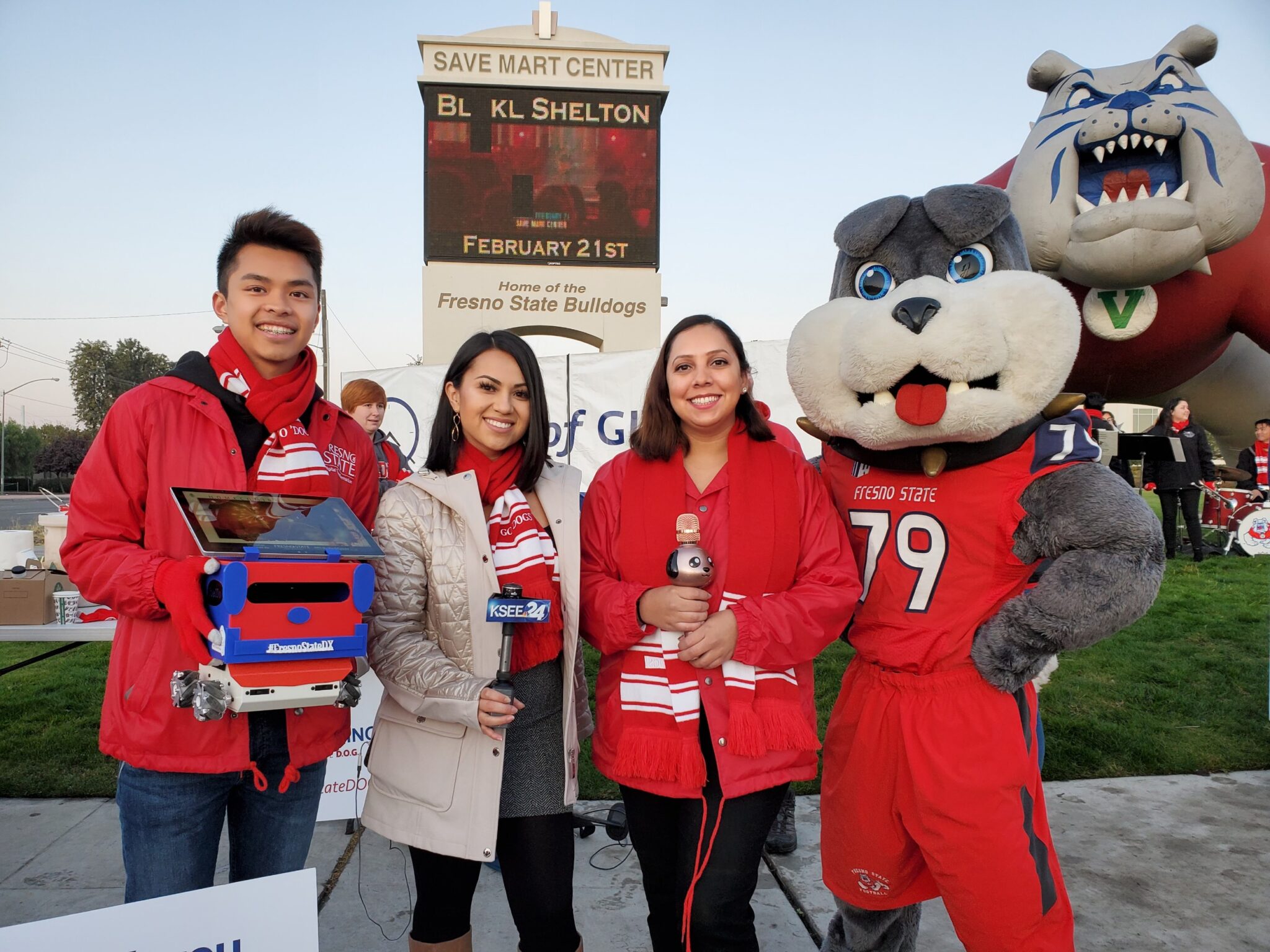 two fresno news anchors, a dxi member holding the bulldog bot and victor the mascot taking a group photo together