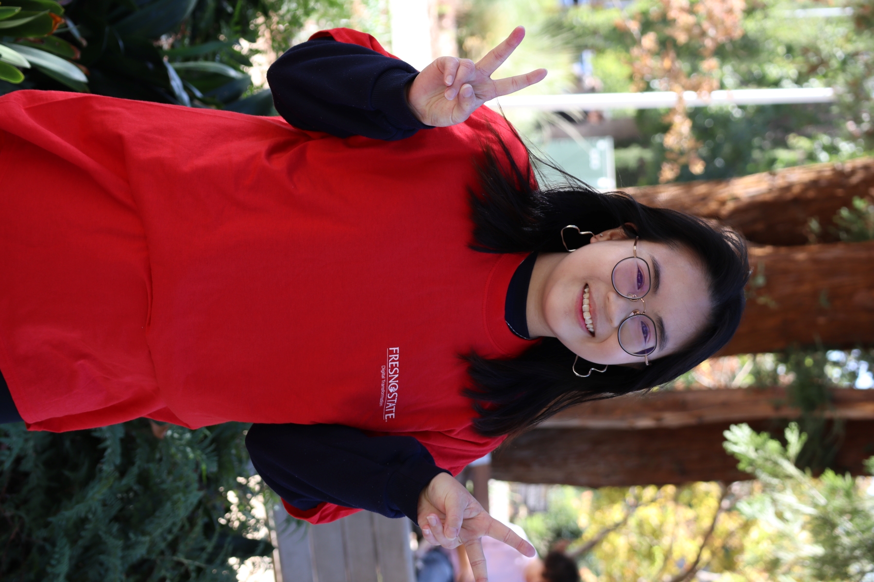 headshot of Rachel smiling and holding up peace signs!