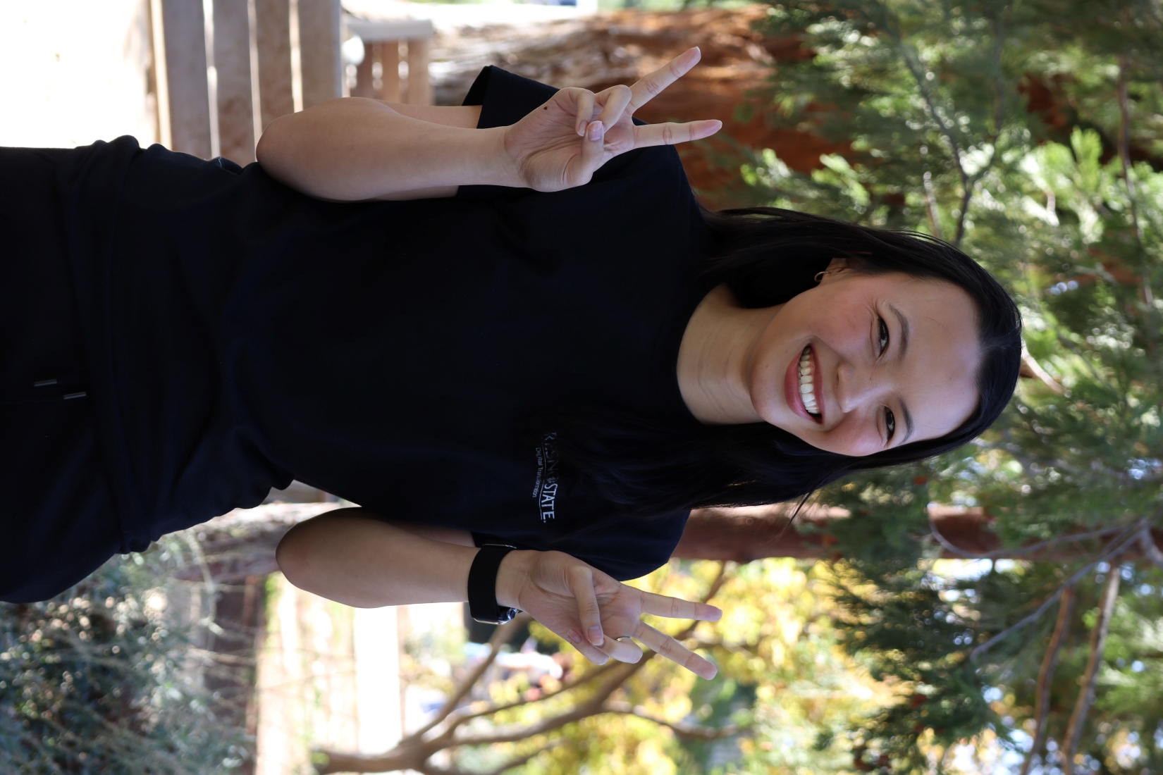 headshot of Tiffany smiling and holding peace signs!