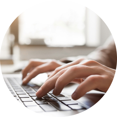 hands typing on a laptop keyboard