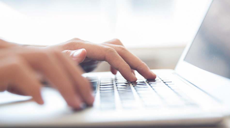 student typing on laptop